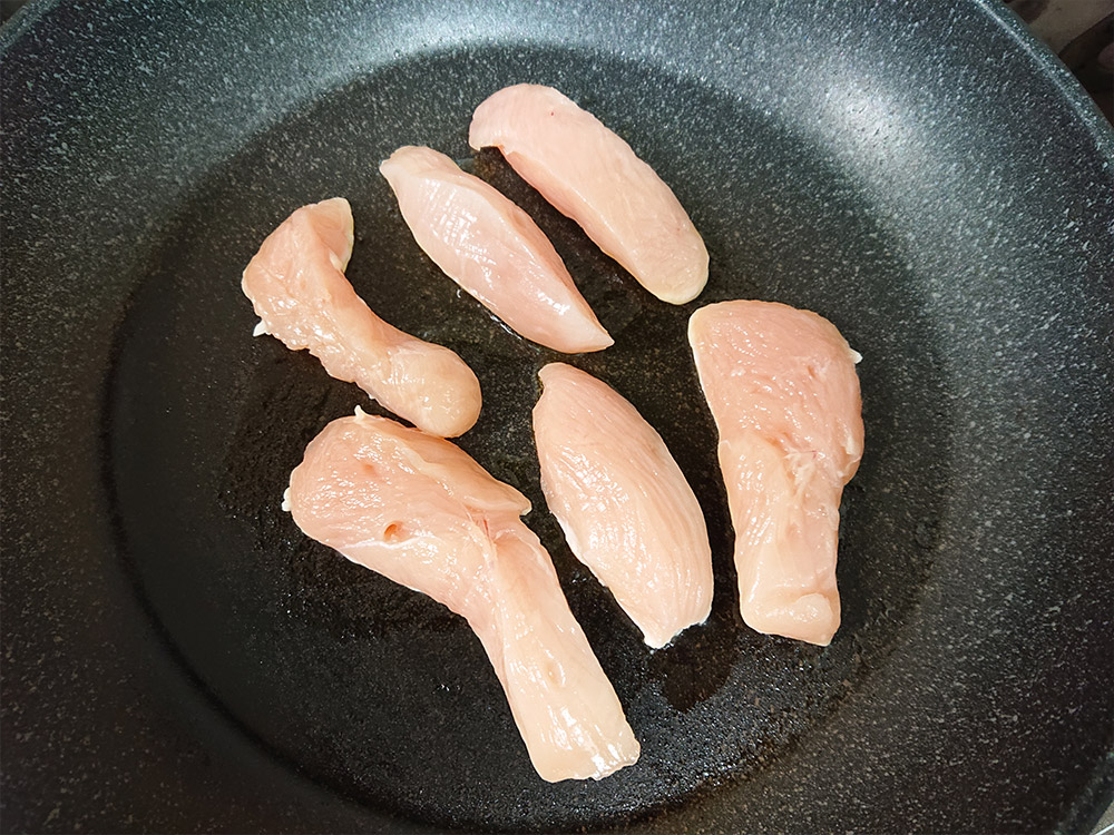 鶏肉をテフロン加工のフライパンに並べて中火にかけ、全体的に焼き色をつける。