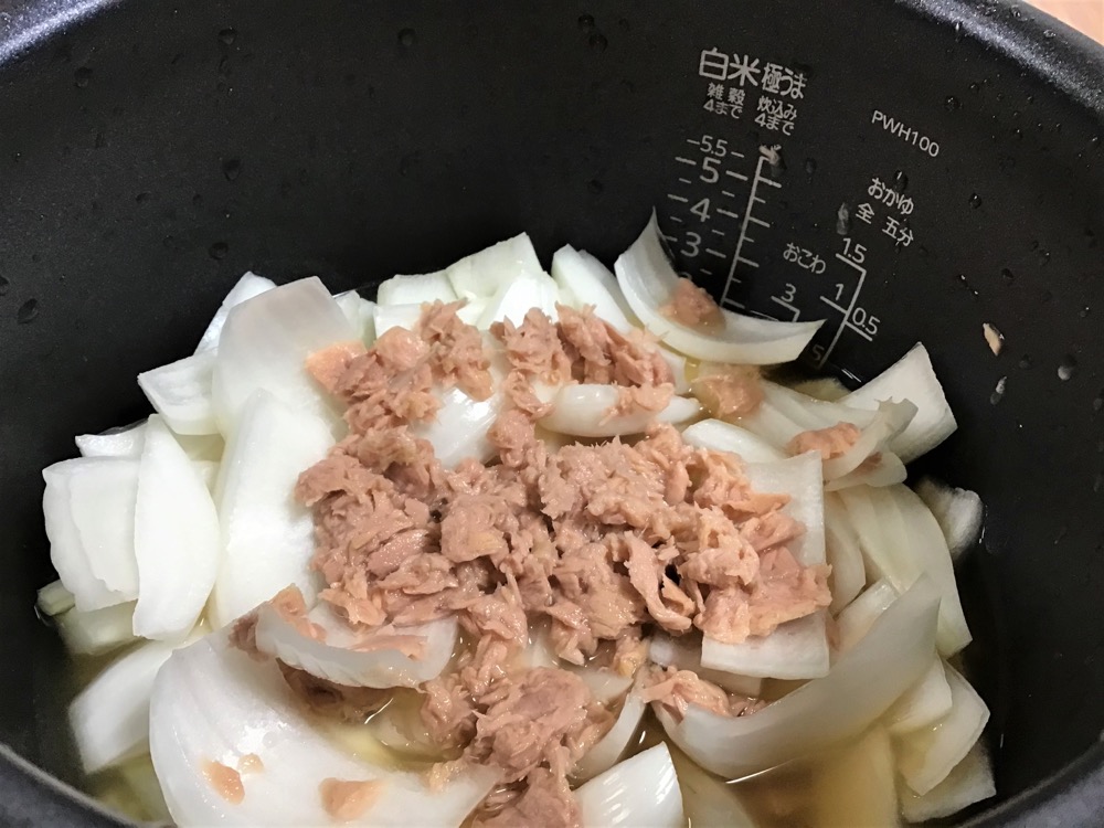 米を研いで炊飯器に入れ、分量の水と調味料を入れ、その上に切った玉ねぎとツナを入れて炊飯する。