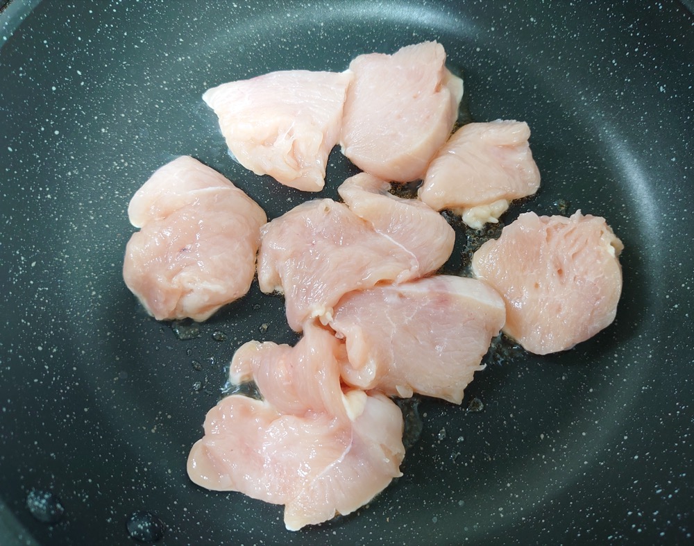 深めのフライパンに鶏肉を入れて両面焼く。なすとだし汁を加えて、柔らかくなるまで煮る。
