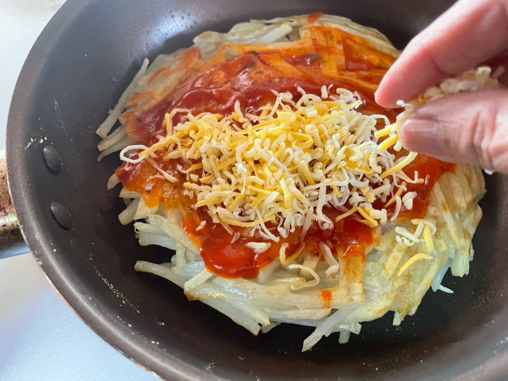 焼いている面に焼き色がついたらひっくり返して同じように焼く。しばらく蓋をして中まで火を通し、上にケチャップ（ピザソース）ハム・チーズ・ピーマンを散らし、再び蓋をしてチーズが溶けるまで焼く。