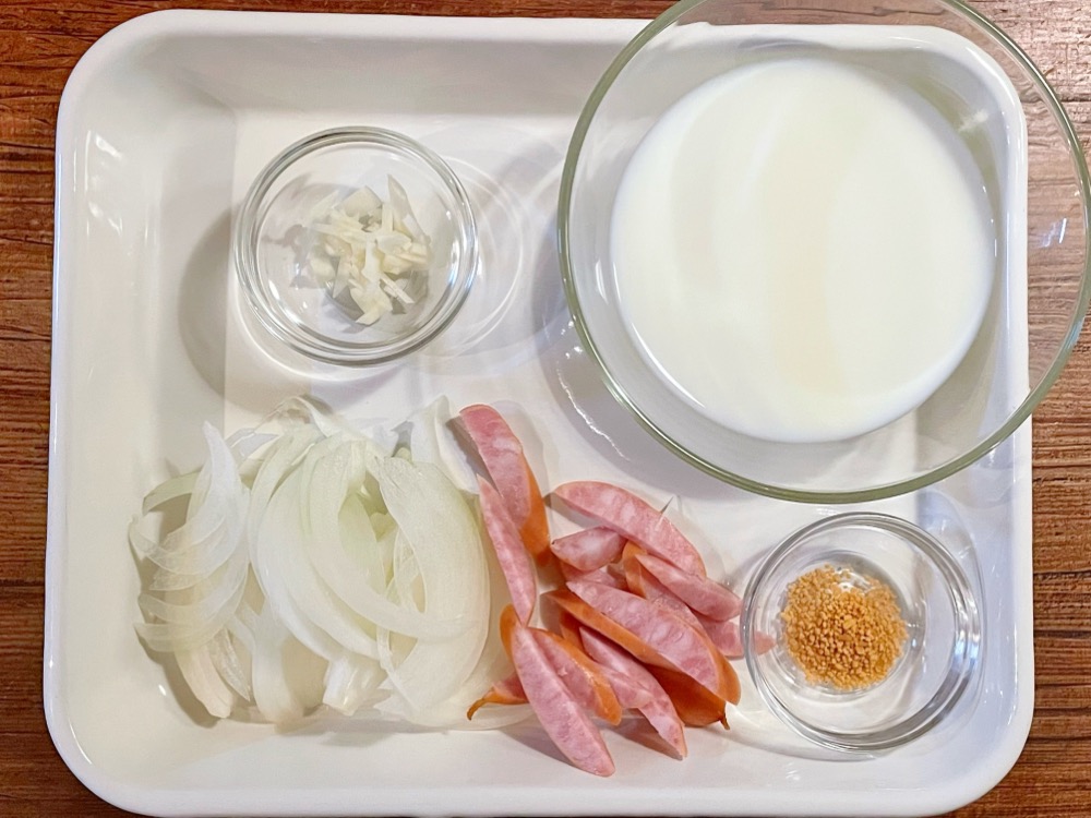 クリームソースの他の材料を切って用意する。玉ねぎは薄切り。ソーセージも合わせて薄切りにする。にんにくはみじん切りにする。