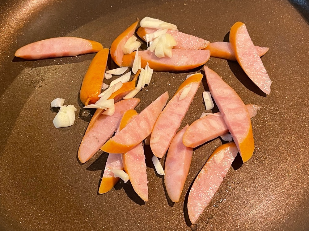 フライパンに油を引かずに、にんにくとソーセージを入れて火にかける。ソーセージの油をじっくり出して、にんにくの香りも引き出す。