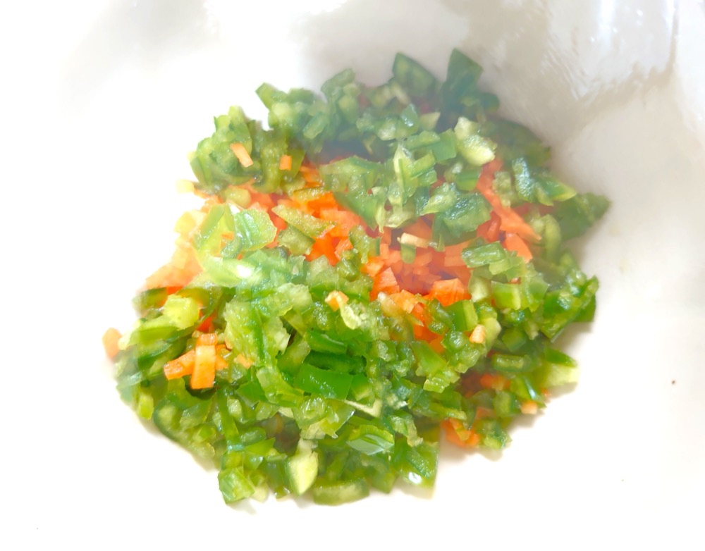 にんじん、ピーマンはみじん切りにする。耐熱容器に入れてラップをし、レンジ600wで3分加熱する。