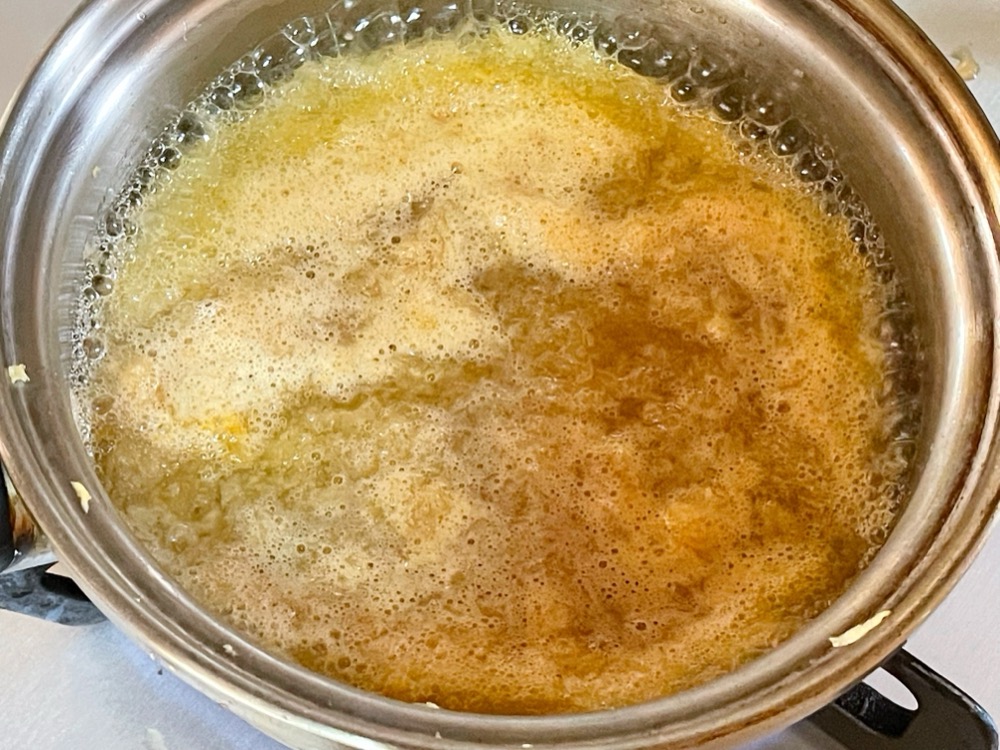 鍋に水と砂糖を入れて煮立たせ、りんごを2～３分煮る。あくが出るのですくっておく。