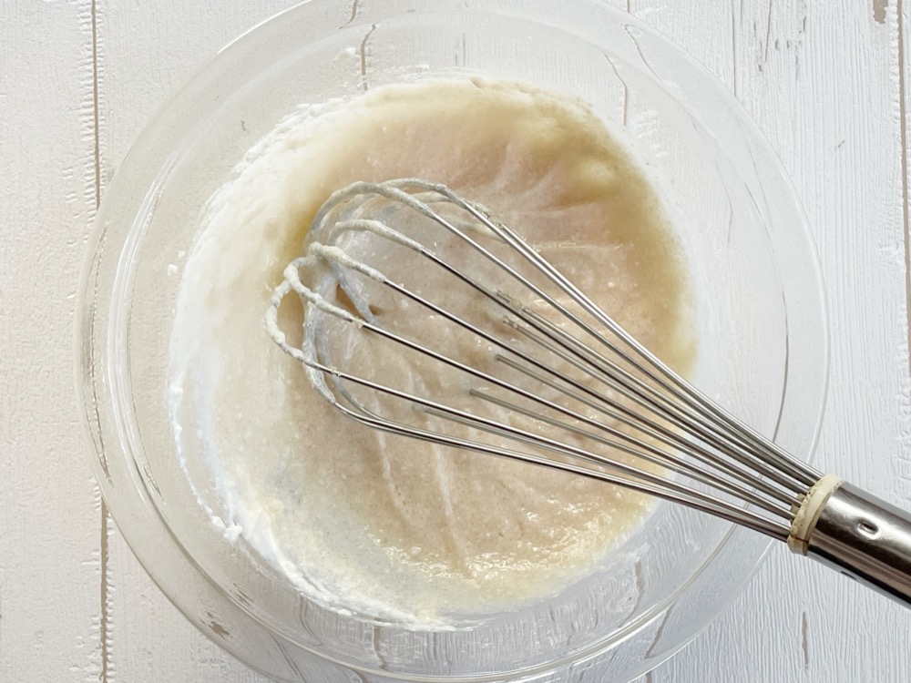 ボウルに豆腐を入れてホイッパーでぐるぐるかき混ぜ、なめらかにする。オーブンは180度に予熱しておく。