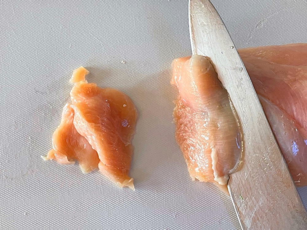 鶏むね肉は繊維を断ち切る方向で、斜め薄切りにする。