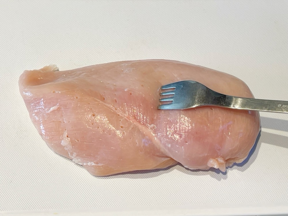 鶏むね肉の皮をひいて、フォークでブツブツと穴を開ける。
