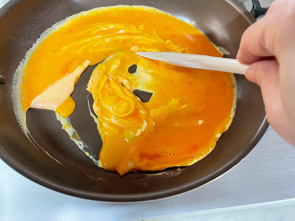 フライパンを中火でゆっくりと温め、卵を一気に流して、ヘラで周りから大きく混ぜながらふんわりした半熟の炒り卵を作る。半熟のうちに別の器に取り出す。