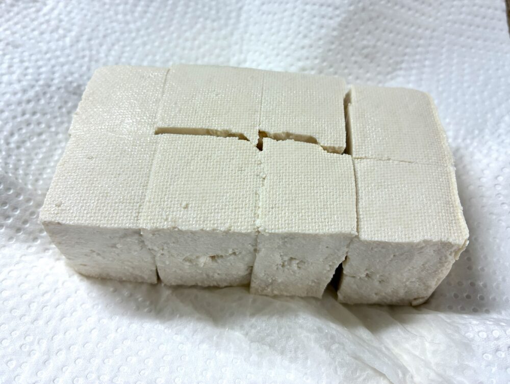 豆腐を8等分にカットしてペーパータオルで包み、電子レンジ600wに1分かけて水切りをする。