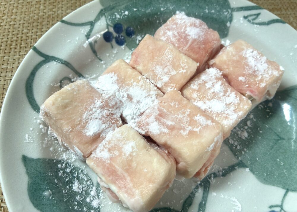 2の豆腐を豚しゃぶ肉で包み、周りに片栗粉を振りかける。