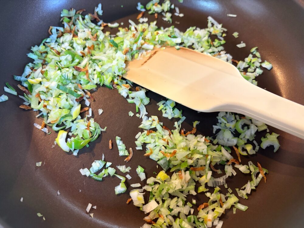 フライパンにねぎのみじん切り、干しエビを入れ中火以下でゆっくりと炒める。ねぎの水分で蒸し焼きになって火が通る。ガラスープの素も加える。