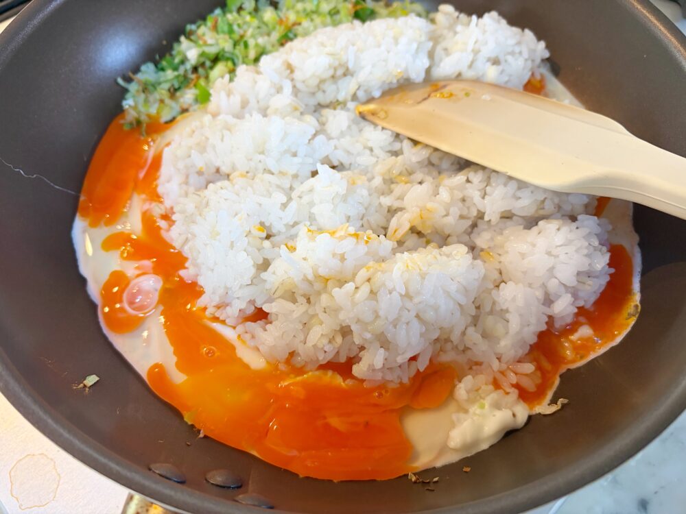 白身が焼けて香りがしてきたら、黄身を潰しながらご飯を投入。卵でご飯粒を包むつもりで炒め合わせる。