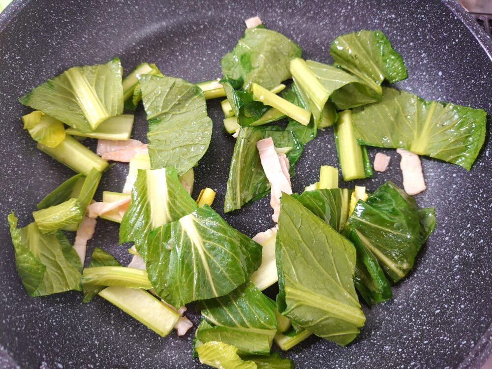 フライパンに油、にんにくを入れて熱し、香りが立ったら小松菜、ハムorベーコンを加えて炒める。