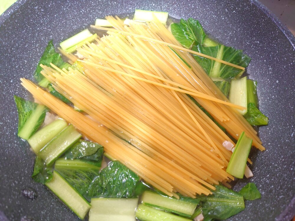 2に水、めんつゆを加えて煮立てる。スパゲティを加えて蓋をし、表記の時間より1分短めに茹でる。