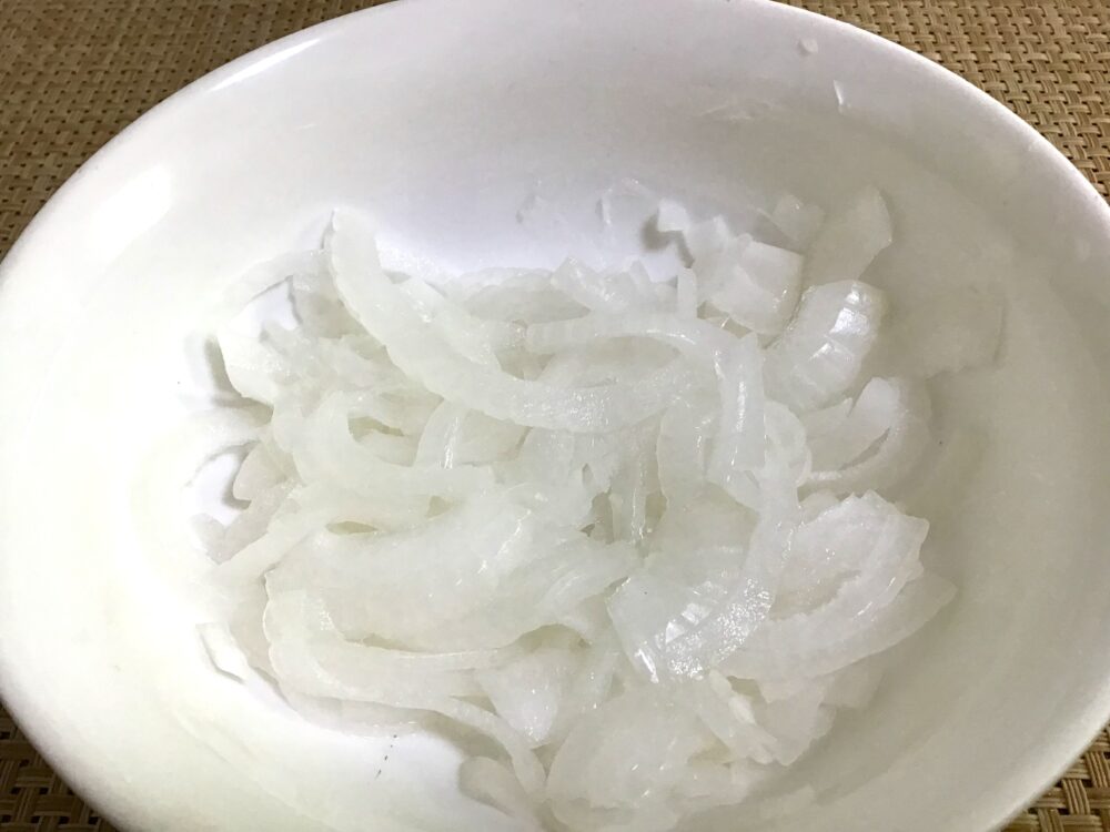 新玉ねぎは皮をむき、縦1/2にカットしてから、できるだけ薄くスライスする。