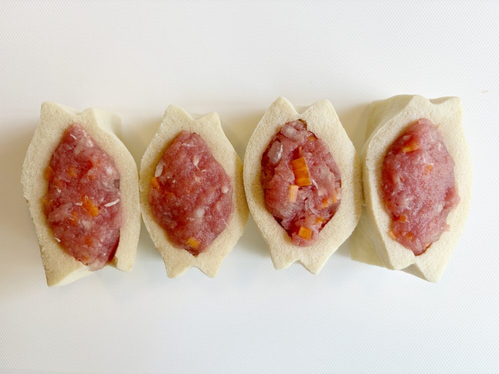 ひき肉に、にんじんと玉ねぎを入れ、調味する。高野豆腐に切り込みを入れてポケットを作り、そこに肉だねを詰める。
