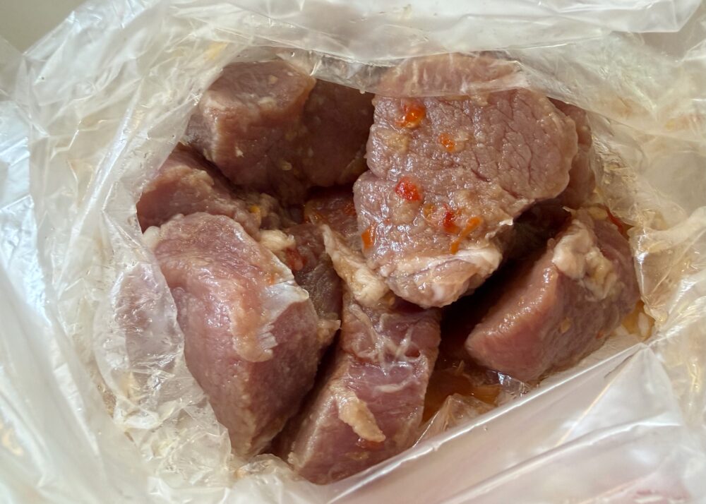 にんにくをすりおろし、ビニール袋に調味料を入れ、切った肉を入れて軽く揉みこんで15分ほど置く。