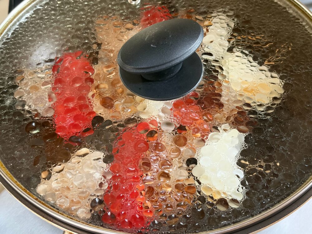 串焼きの表が焼けたらひっくり返して、袋に残ったタレをかけ、蓋をして中火以下で3～4分蒸し焼きにする。