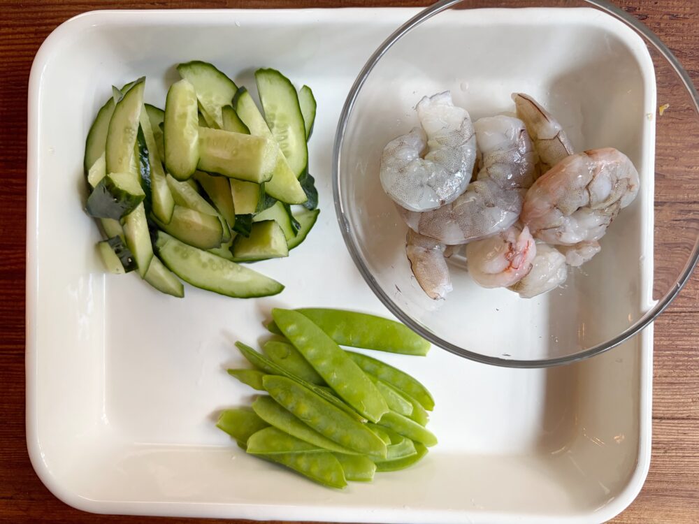 えびは、塩と酒少々（分量外）を振って下味をつけておく。きぬさやは筋を剥いておく。きゅうりは縦半分にして、きぬさやに合わせて斜め薄切りにする。