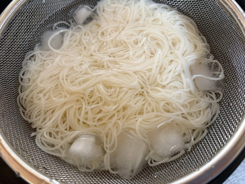 そうめんは袋に書いてある時間茹でてから、氷水で締める。ザルにあげて水気を切る。