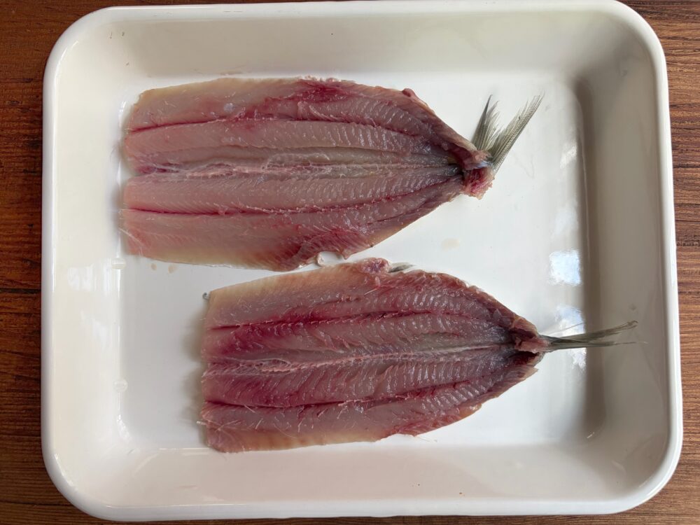 いわしの頭を取り、内臓をきれいに取り除き、きれいに洗って水気を拭き取ったら、腹開きにして中骨を取っておく。