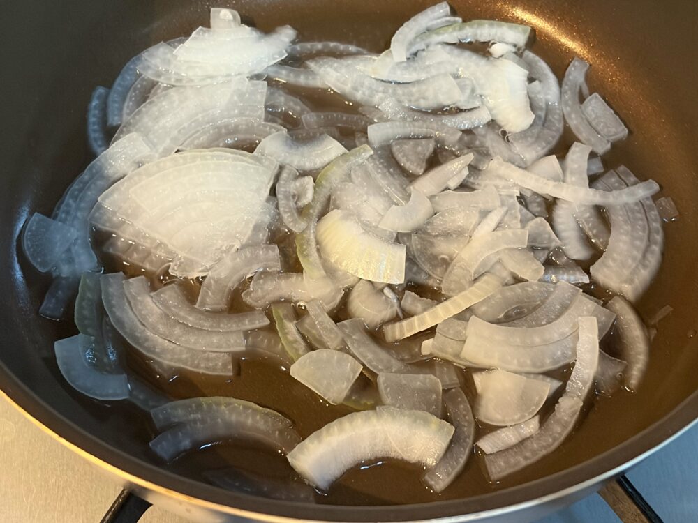 フライパンに薄切りの玉ねぎを広げ、水半分を入れて蓋をし、弱火で蒸し煮にして、しんなりさせる。