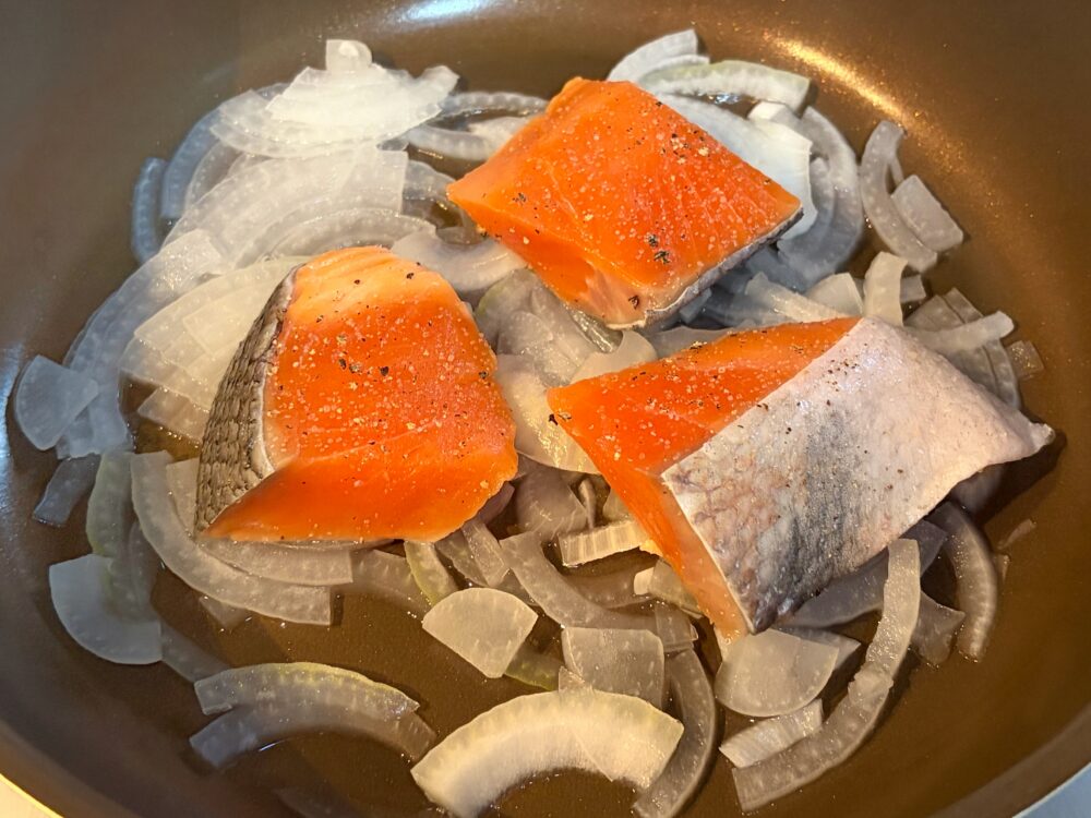 鮭を並べ、白ワインを振りかけ、残りの水も加えて蓋をし、さらに5分ほど蒸し煮にして、鮭に火を通す。
