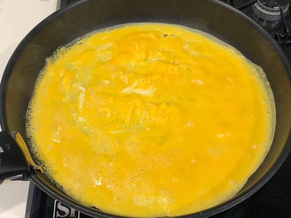 卵にbを加えて溶きほぐし、薄く油を引いたフライパンに流し入れる。