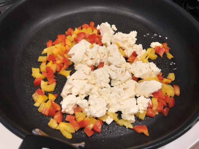 フライパンに油を熱してパプリカを炒め、1〜2分炒めたら木綿豆腐を加えてさらに炒める。