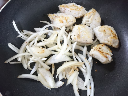 テフロン加工のフライパンで白身魚を両面焼き、空いているスペースに玉ねぎを加えてサッと炒める。