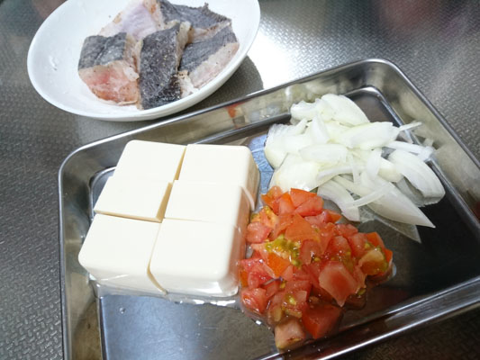 白身魚は水気を拭き取ってからひと口大に切り、片栗粉を薄くまぶす。豆腐はひと口大、トマトは1cmの角切り、玉ねぎは薄切りにする。
