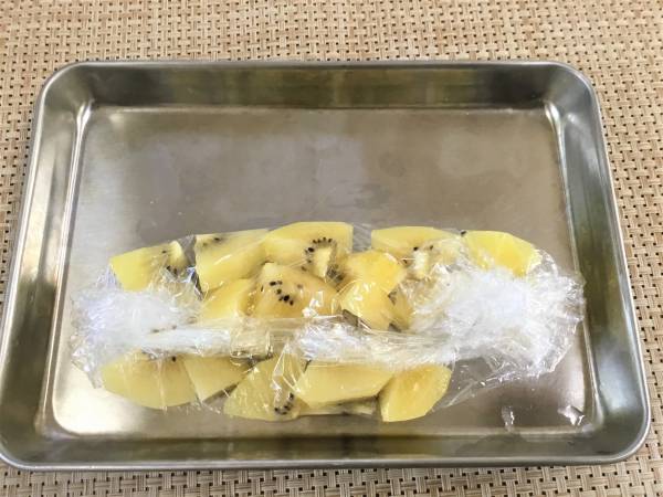 ゴールデンキウイは、大き目のイチョウ型に切ってからラップに包み、冷凍庫で凍らせる。