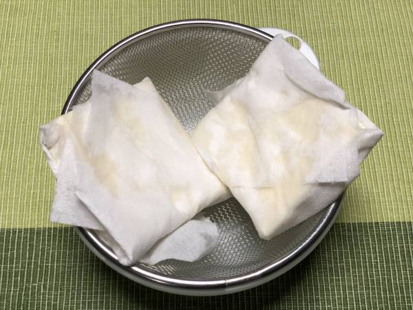 木綿豆腐は半分の厚さに切り、キッチンペーパーに包んでザルの上で20分ほど水切りしておく。玉ねぎはみじん切り、車麩はミキサーで砕いておく。
