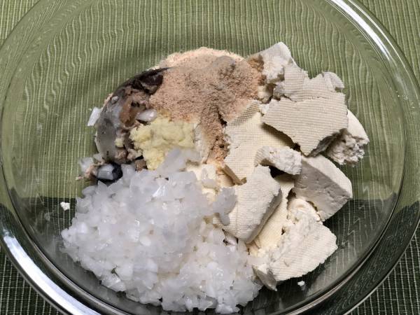 ボウルに水切りした木綿豆腐、汁を切った鯖缶、玉ねぎ、車麩、塩麹、すりおろした生姜を加え、混ぜる。