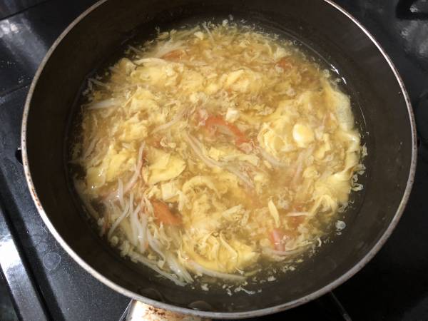 小鍋でだし汁を温め、醤油・みりんを加え、塩で味を調える。沸騰したら水溶き片栗粉を加えて、とろみが付いたら、溶き卵とかにかまぼこを加え、あんかけをつくる。