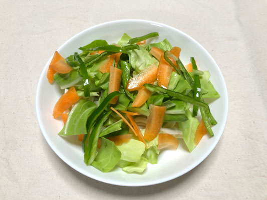 耐熱皿に冷凍うどんを置き、その上に野菜をのせて、水を回しかける。ふんわりとラップをして電子レンジ600wで4分加熱する。